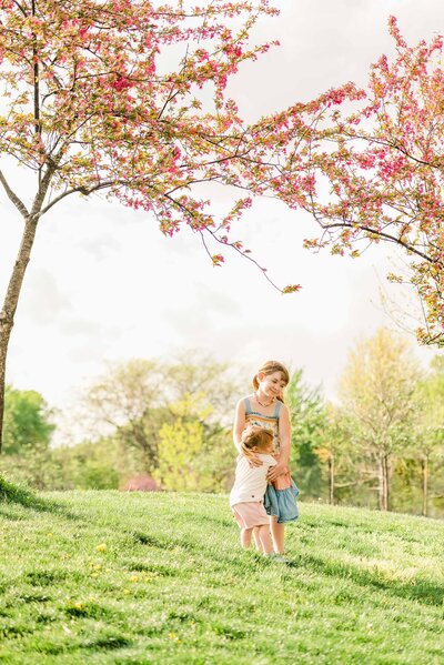 Mom and young daughter in a sunny, grassy meadow by Oak Park, IL family photographer Kristen Hazelton