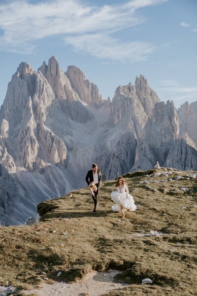 couple running on elopement day at Tre Cime di Lavaredo