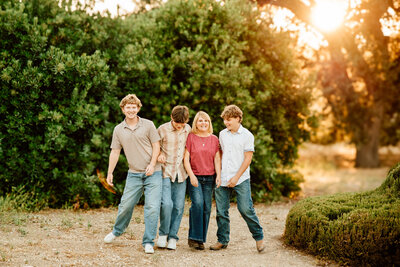 Photographer in San Luis Obispo captures Joyful, backlit image of a mom with her 3 teenaged sons
