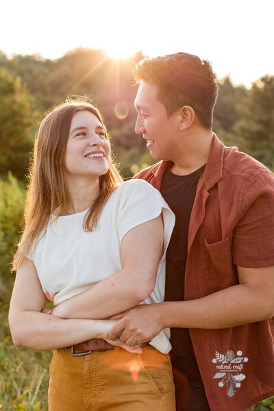 Engagement photo in Blowing Rock, NC of man and woman looking at each other during a sunset engagement session.