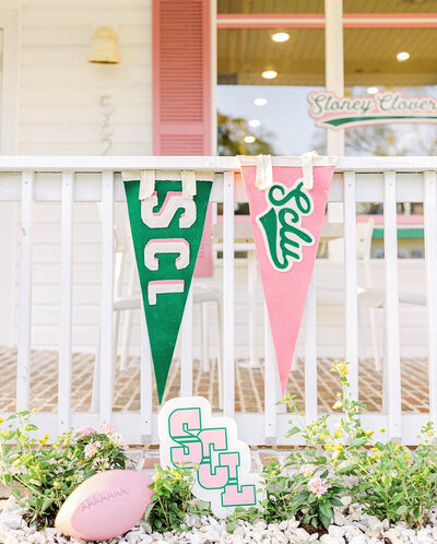 Pink and green pennant flags hanging on a porch railing