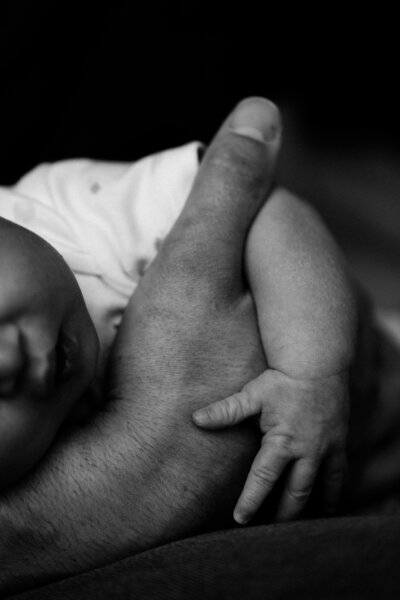 father holding baby's hand