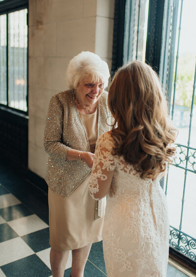 Bride and grandmother have an emotional moment together holding hands the morning of her wedding day.