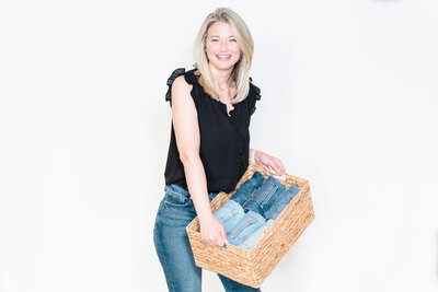 brand photo of a professional organizer holding a box full of clothing