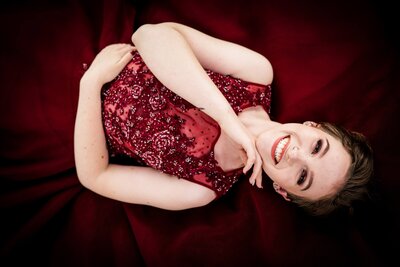 senior girl smiling in maroon dress