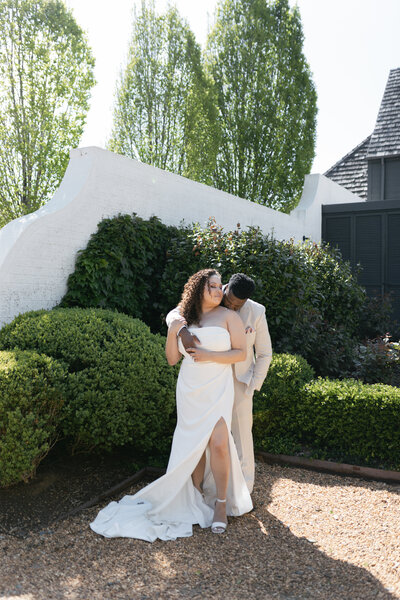 bride and groom photos of bride standing in front and groom hugging from behind