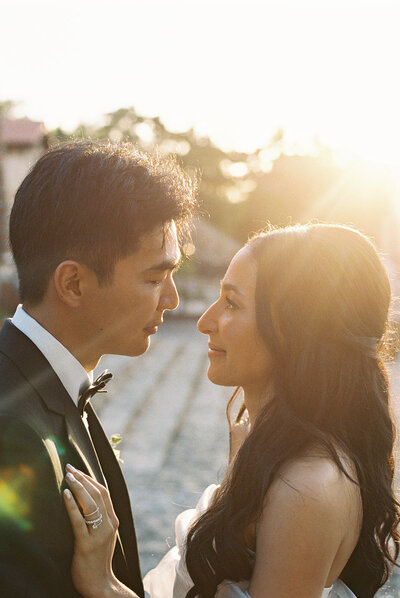 Bride and groom gazing into each other’s eyes during golden hour at Altos de Chavón, the sunlight wrapping them in warmth — romantic portrait by Asia Pimentel Photography.