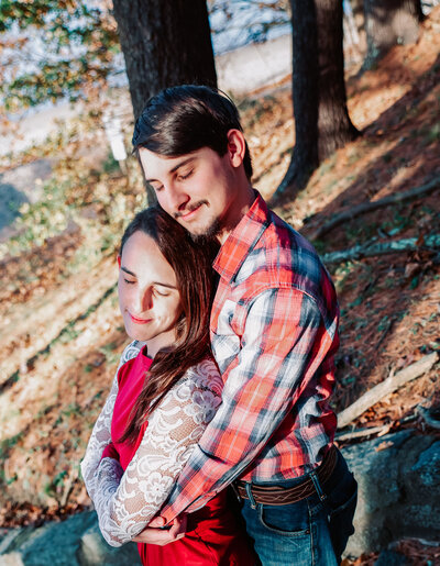 couple standing in woods engagement session