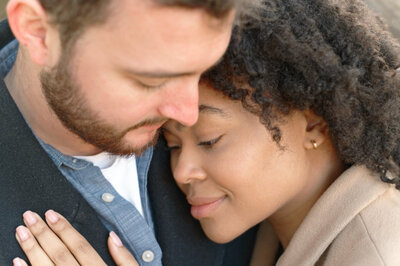 engaged couple with bride resting head on grooms chest