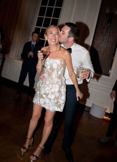 A bride and groom stand closely, facing each other in front of a wooden door with ivy-covered stonework. The groom wears a black tuxedo, and the bride holds a bouquet of flowers. chicago wedding photographers Allison Francois from Greencrest captures every precious moment of this perfect wedding day.