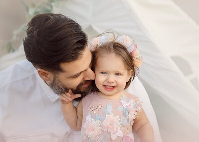 Dad kissing baby daughter on the cheek at a Malibu beach photoshoot with Elsie Rose Photography