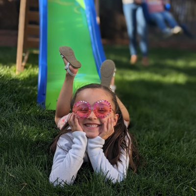Ashley's daughter Suraya laying down smiling at camera
