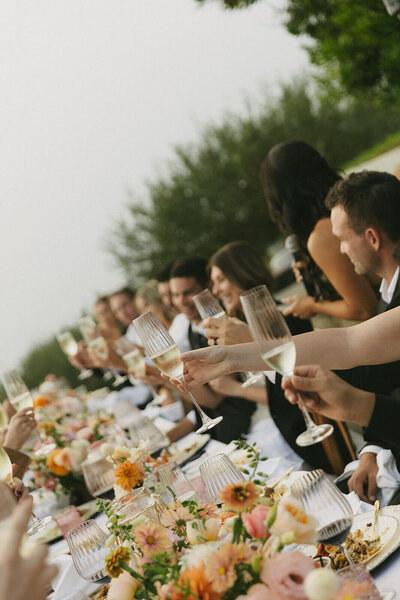 Joyful toast during an outdoor wedding reception in Big Sur