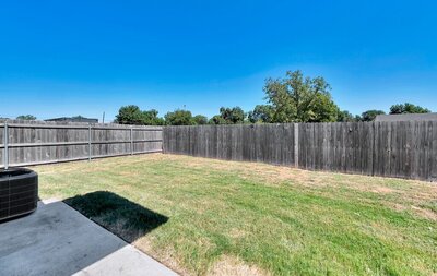 Fenced in backyard of this 2-bedroom, 1 bathroom vacation rental home located 4 minutes from delicious Magnolia Table and 5 minutes from the beautiful Baylor campus in Waco, TX