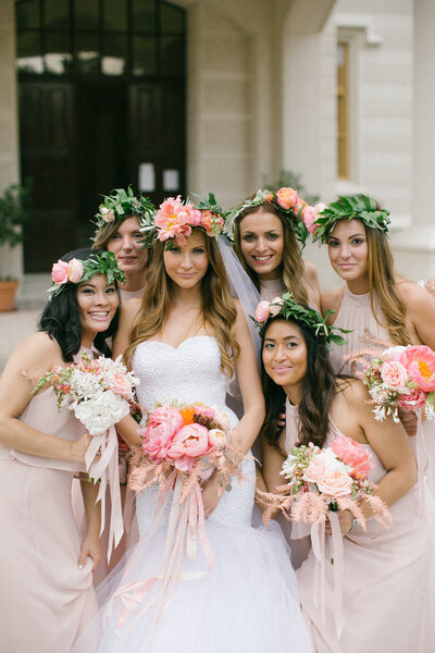 South Asian bride getting ready with women in traditional sarees inside a softly lit room, paired with a group portrait of a Western bride and bridesmaids in soft pink dresses and flower crowns, holding pastel bouquets. Wedding photography showcasing multicultural, emotional moments and luxury bridal styling.