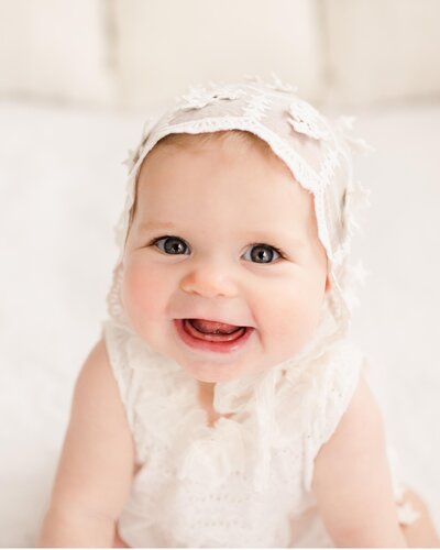 smiling 6 month old baby girl during her photo session in Pensacola fl studio