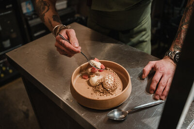 Chef adding a final touch to a dessert with scoops of ice cream and decorative wafers at Sael Birmingham restaurant.