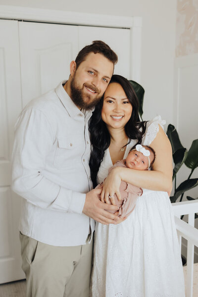 Parents smiling with newborn baby daugher