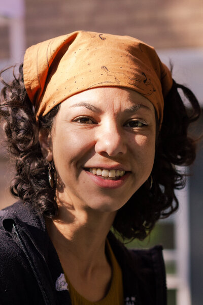 Headshot of Mexican-American ceramic artist Krissy Ramirez smiling as she teaches students at MSU Minot how to throw ceramics