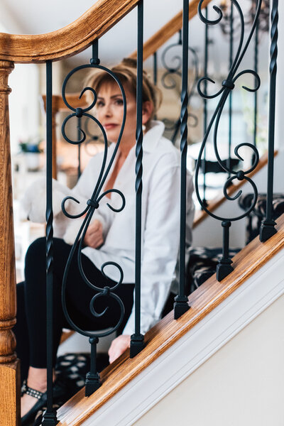 Charisse Marei sits on her home staircase