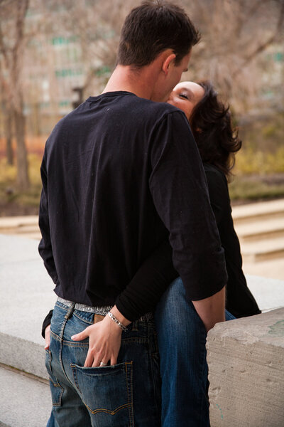 Engagement Photoshoot at the Alberta legislative Grounds  Couple Kissing hands in each others pockets