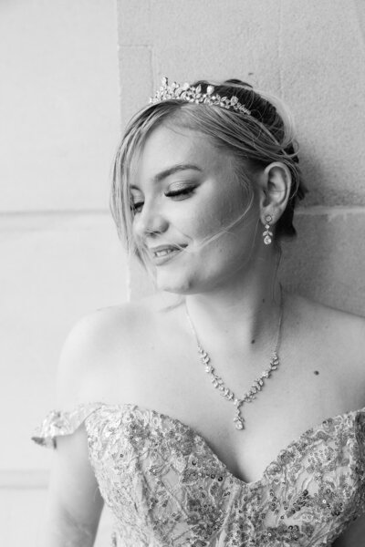 Amazing black and white formal portrait of a girl dressed in a beautiful gown, looking downwards thoughtfully. Moment captured by Julie-Anne Photography.