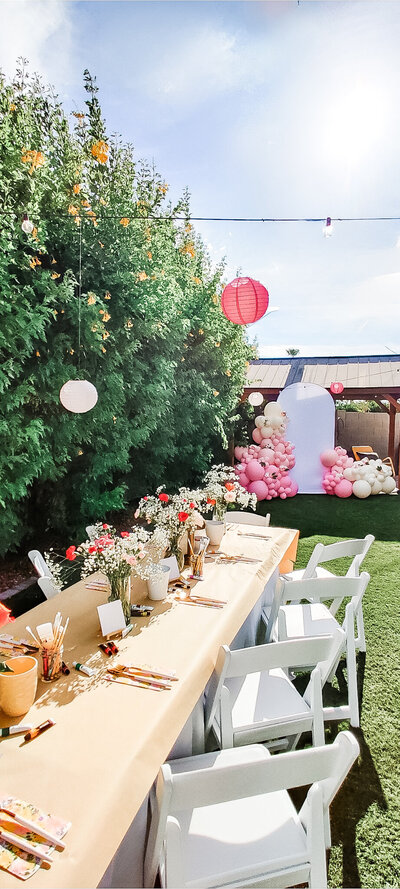 Colorful beach ball balloon decorations with surfboards and themed table setup for a kids’ birthday party in Arizona by Stars and Stripes Events LLC.