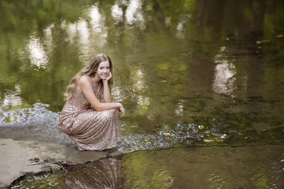 Senior girl wearing a glittery dress beside the water