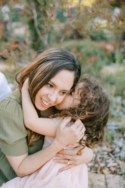 daughter giving mom a kiss
