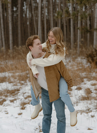 Engaged couple taking winter engagement photos at Rice Creek Park in Minnesota