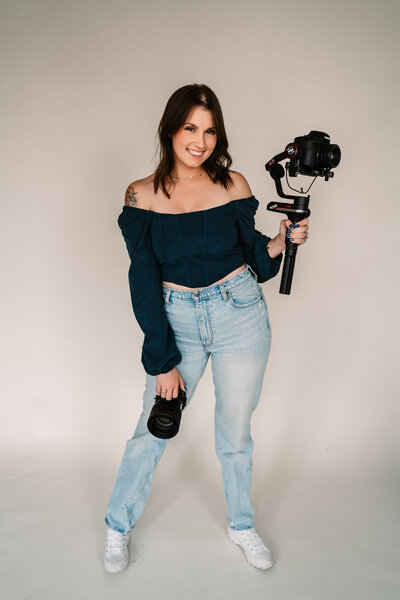 Taylor Smith Photo & Video owner holding canon cameras and videography gimbal.