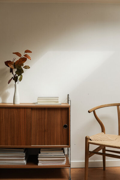 Wishbone chair in huis naast retro kast