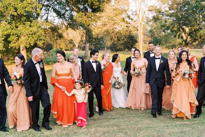 Bridal party dressed in orange colors and cultural Indian wedding attire