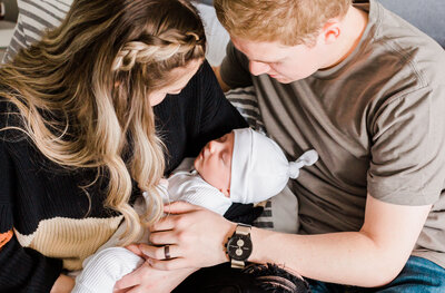 mom and dad holding newborn baby during in home newborn photos