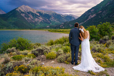 Bride and groom standing together at Twin Lakes with the Collegiate Peaks mountain range behind them during their Buena Vista elopement.