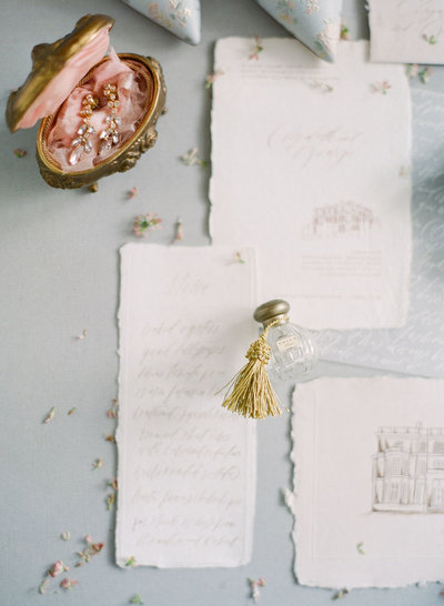 Tocca perfume and a French ormolu trinket box holding petal drip earrings for a luxury wedding flatlay by Willow and Oak