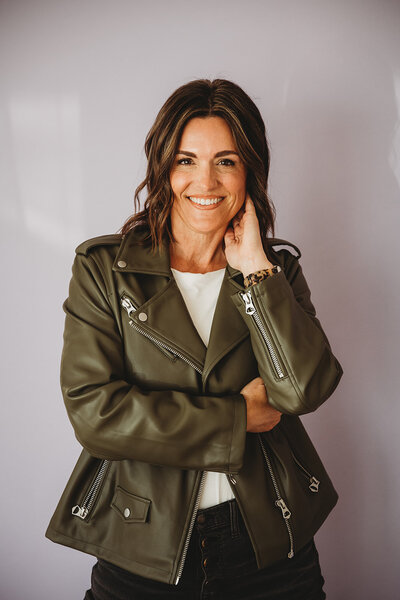 Image of dark-haired woman with arms folded and a smiling face