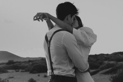 Black and white photo of bride and groom embracing