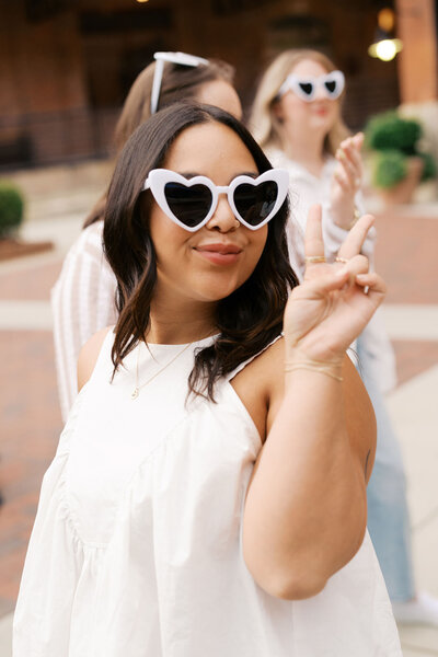 Raleigh event planner Sydney wearing white heart glasses