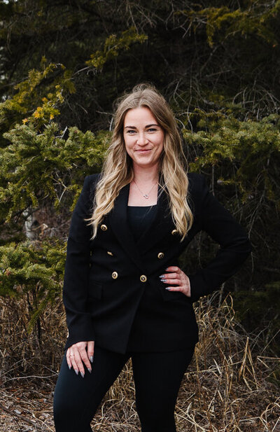 Southern Alberta Realtor Tamara Rzan posing against a rustic background