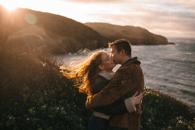 Couple embrace at sunset for their engagement shoot at Hope Cove