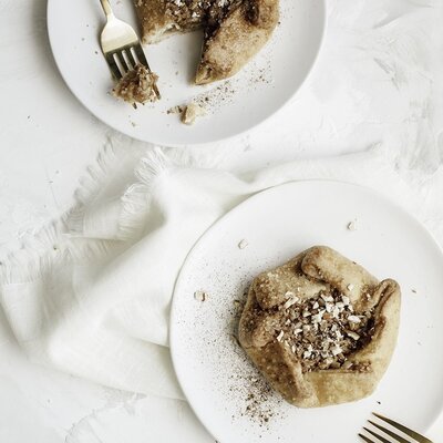 Delicate handmade pastries on crisp white plates and a soft linen background.