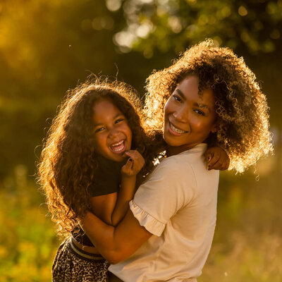 Lachende foto van moeder en dochter in de stralende zon