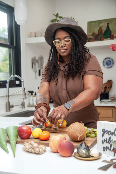 Image of Kristi Mefford, owner of Queen of Kinks, cutting ingredients in kitchen.