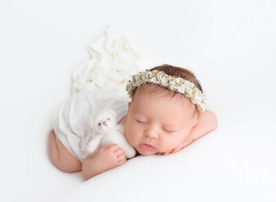 NYC Artistic Newborn Photoshoot Sleeping newborn baby girl wrapped in ivory tones 