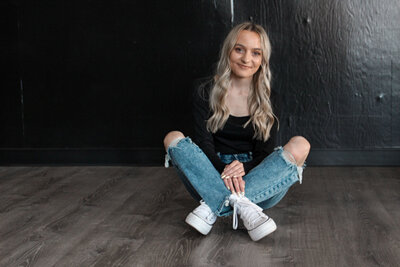 A girl sitting cross legged on the floor