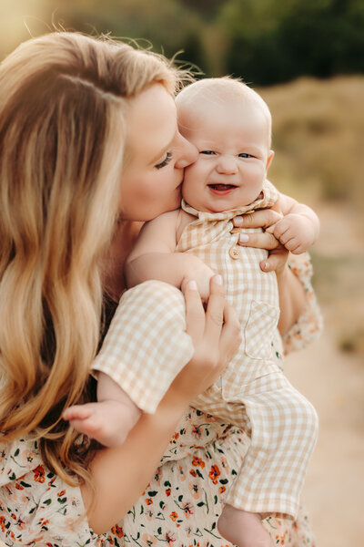 Family Photographer,  Mom giving kisses to smiling happy baby