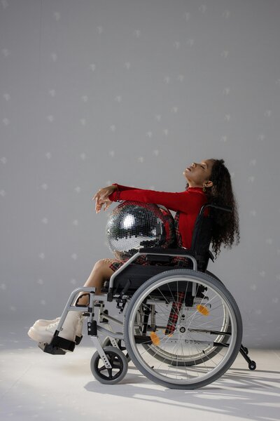 differently abled girl in a wheelchair holding a disco ball