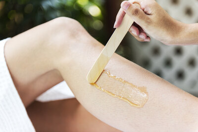 This image features a professional waxing service in action at Book Sothana, a boutique day spa located at 9303 Baymeadows Rd 105, #120, Jacksonville, FL 32256. Book Sothana offers customized waxing services including Brazilian waxes, bikini waxes, and full-body waxing for smooth, long-lasting results. Jacksonville clients trust licensed esthetician Sothana for gentle, hygienic, and thorough waxing experiences. Whether you are booking your first Brazilian wax or maintaining smooth skin with regular waxing treatments, Book Sothana ensures comfort, precision, and care at every visit. Schedule your Brazilian wax, full-body wax, or customized waxing service today by calling (904) 597-0867 or visiting https://booksothana.com/. Experience waxing services in Jacksonville that blend expert technique with a comforting, personalized touch