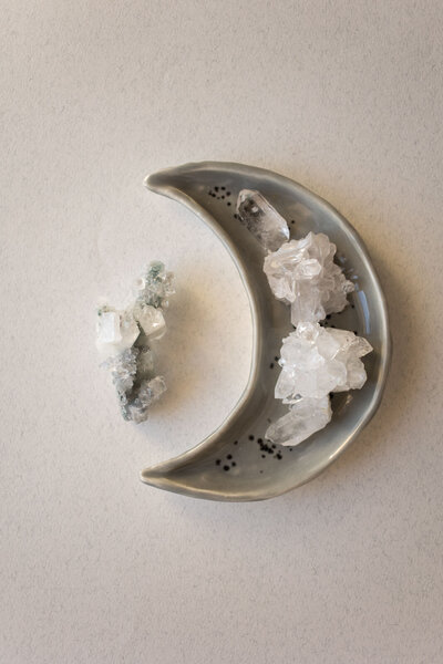 Crystals sitting in a half moon shaped dish